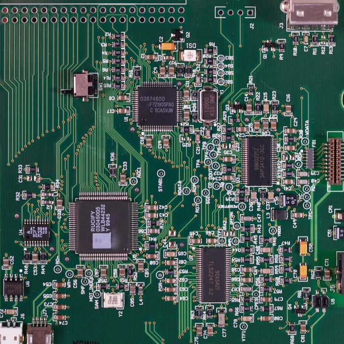 Detailed image of a green circuit board featuring various components and microprocessors.