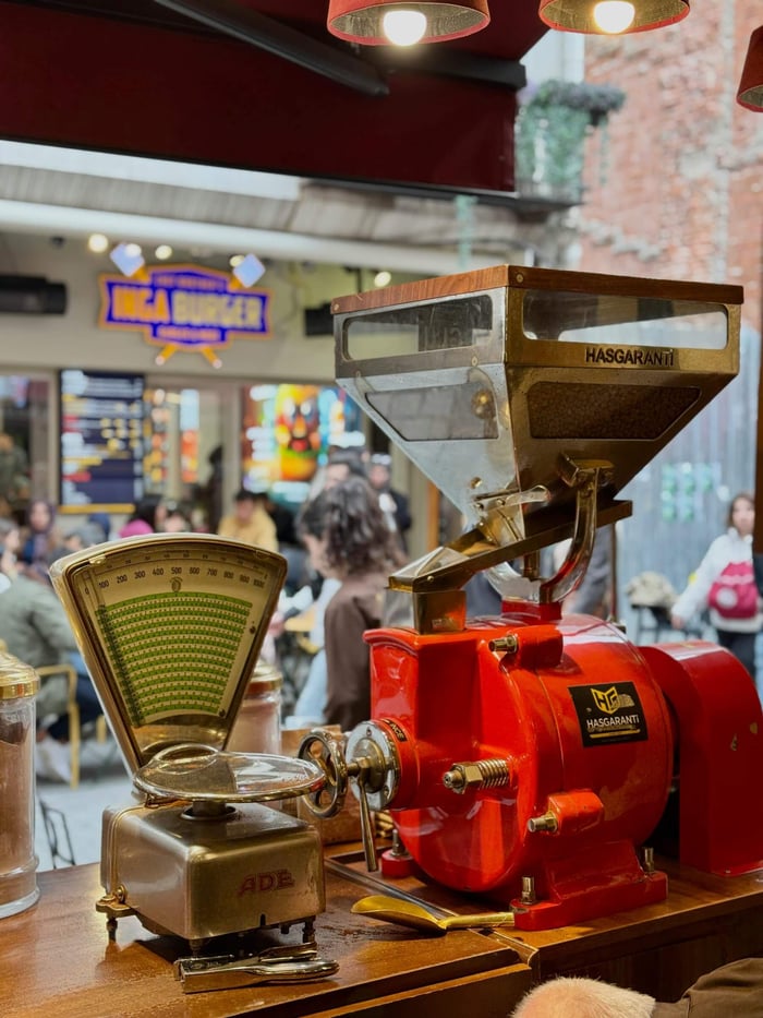 A vibrant scene capturing a vintage coffee grinder in a bustling İstanbul café.